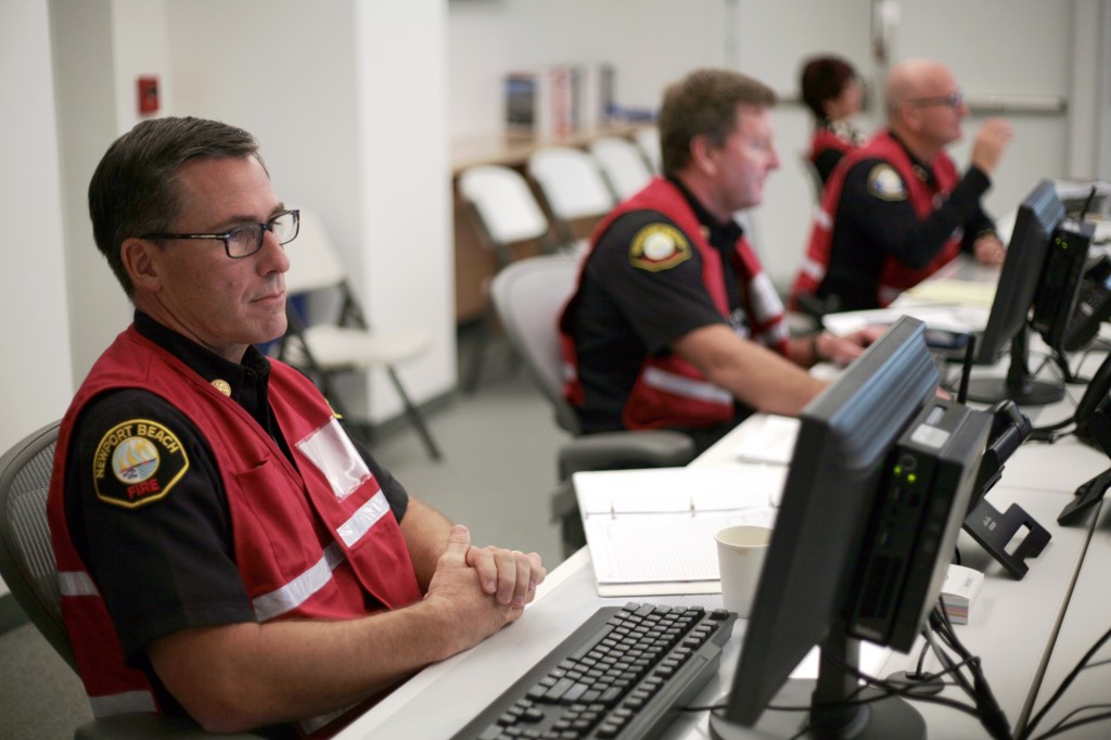 NBFD Fire Line Battalion Chief Chip Duncan works on his computer during the tsunami drill on Thursday.