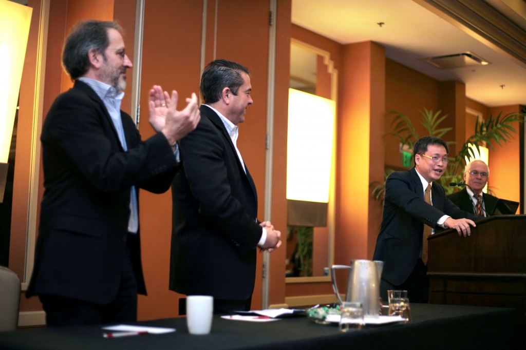 (left to right) Jay Famiglietti, University of California, Irvine professor and member of the Santa Ana Regional Water Quality Control Board, and Shawn DeWane  applaud as Harry Seah praises OCWD.