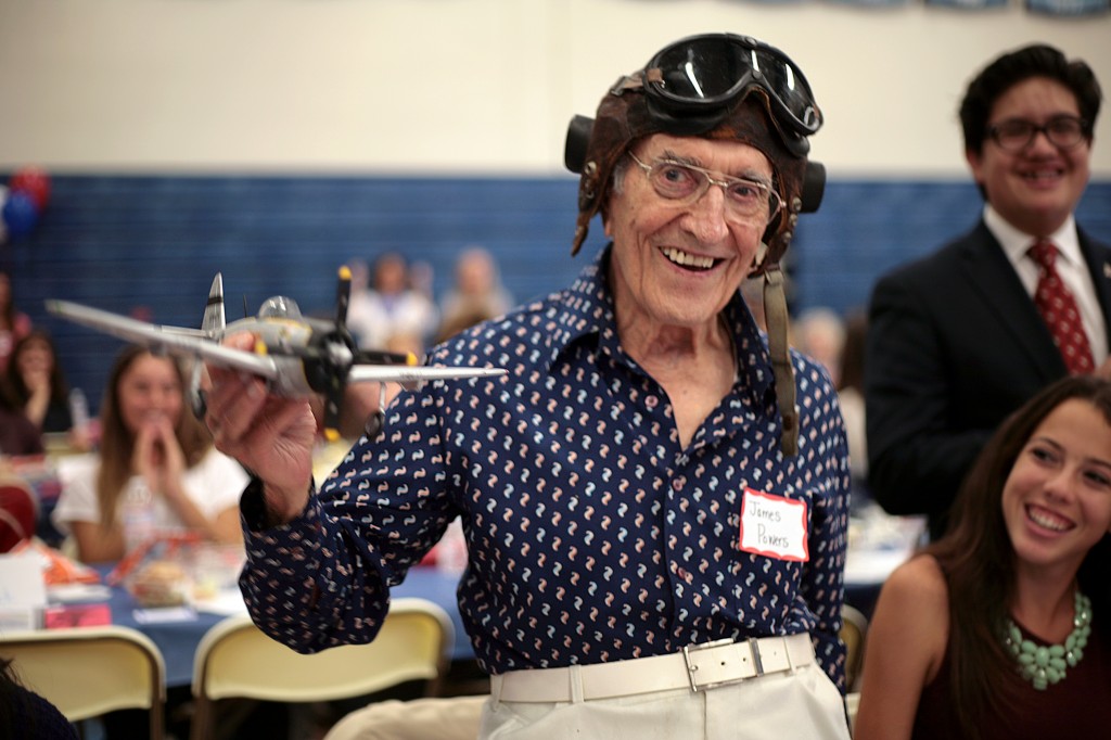 U.S. Air Force WWII veteran James Powers, 93, of Irvine, smiles as his Corona del Mar High School Living History group introduces him on Thursday. The model plane he’s holding is similar to those he flew in the war. — All photos by Sara Hall