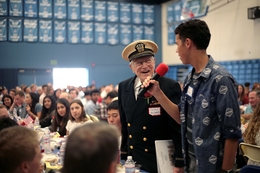 Veteran Lorimer McConnel laughs as his student group introduces him. 