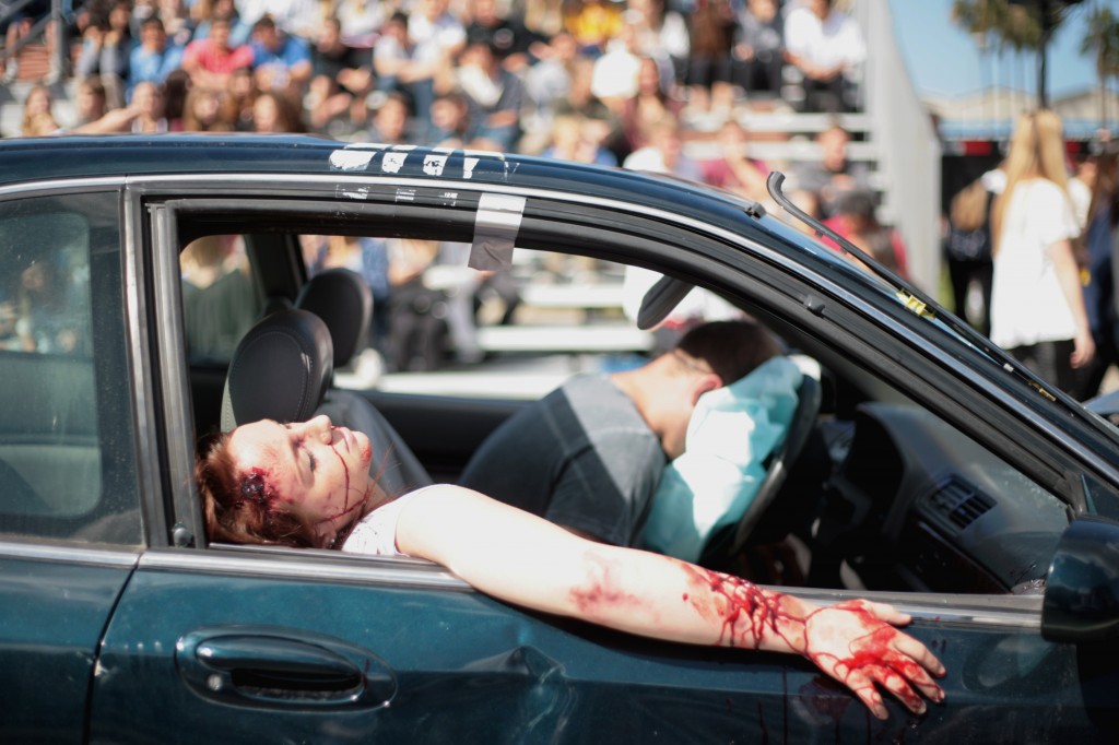 Corona del Mar High School seniors Natalie Sullivan and Ricker Hausam act as victims in a staged DUI accident Tuesday as part of the “Every 15 Minutes” program.