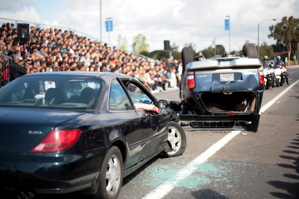 A simulated scene of a triple fatality, two-vehicle collision unfolds in front of Corona del Mar High School students on Tuesday. The staged scene was part of “Every 15 Minutes” program at CdM this week