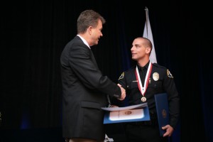 Scott Peotter (left), Field Representative for Assemblyman Allan Mansoor and City Council candidate, shakes the hand of officer Joseph DeJulio, who earned the Lifesaving Award. — Photo by Sara Hall