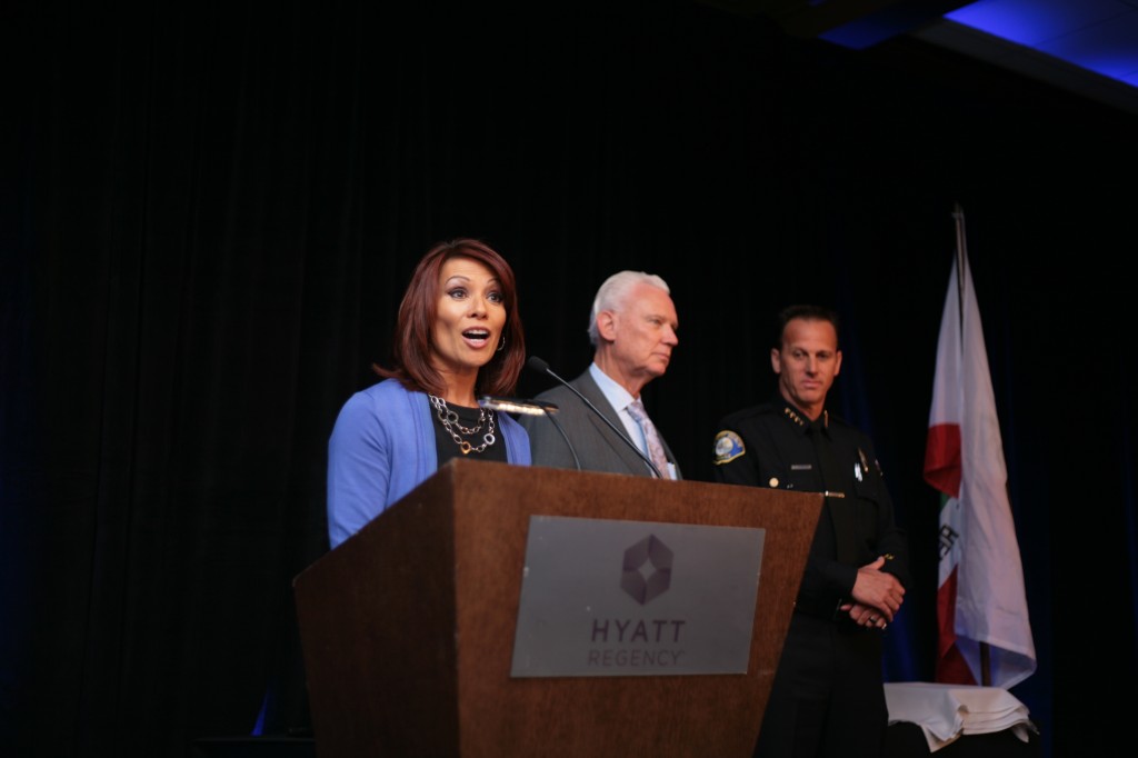 Event announcer Eileen Frere speaks as (left to right) Mayor Rush Hill and Chief Jay Johnson listen. — Photo by Sara Hall