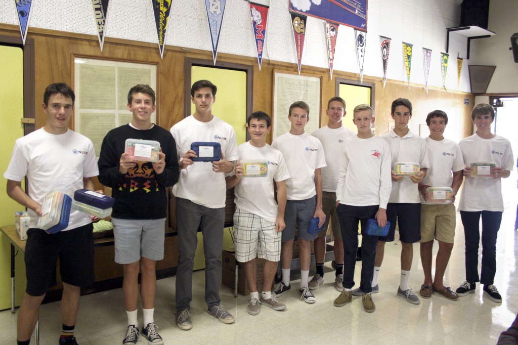 The NLYM poses for a group photo with the school supply boxes they donated. 