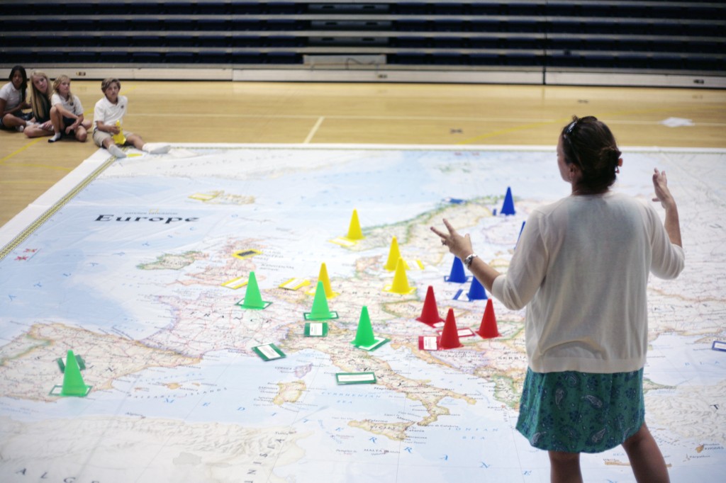 Harbor Day history teacher, Jennifer Fenner, explains an activity that the kids can play - and learn - using the giant National Geographic Traveling Map of Europe on Thursday. — All photos by Sara Hall ©