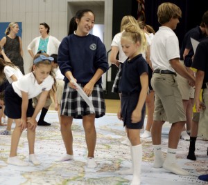 Seventh grader Michaela Phan, 12, helps Ashley Pratt and Isabella Fawaz, both 8, during a geography game on Thursday.