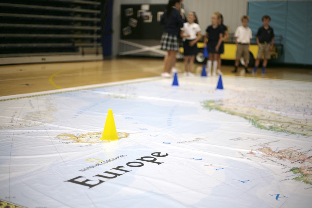 Kids play a game on the giant map of Europe at Harbor Day School on Thursday.