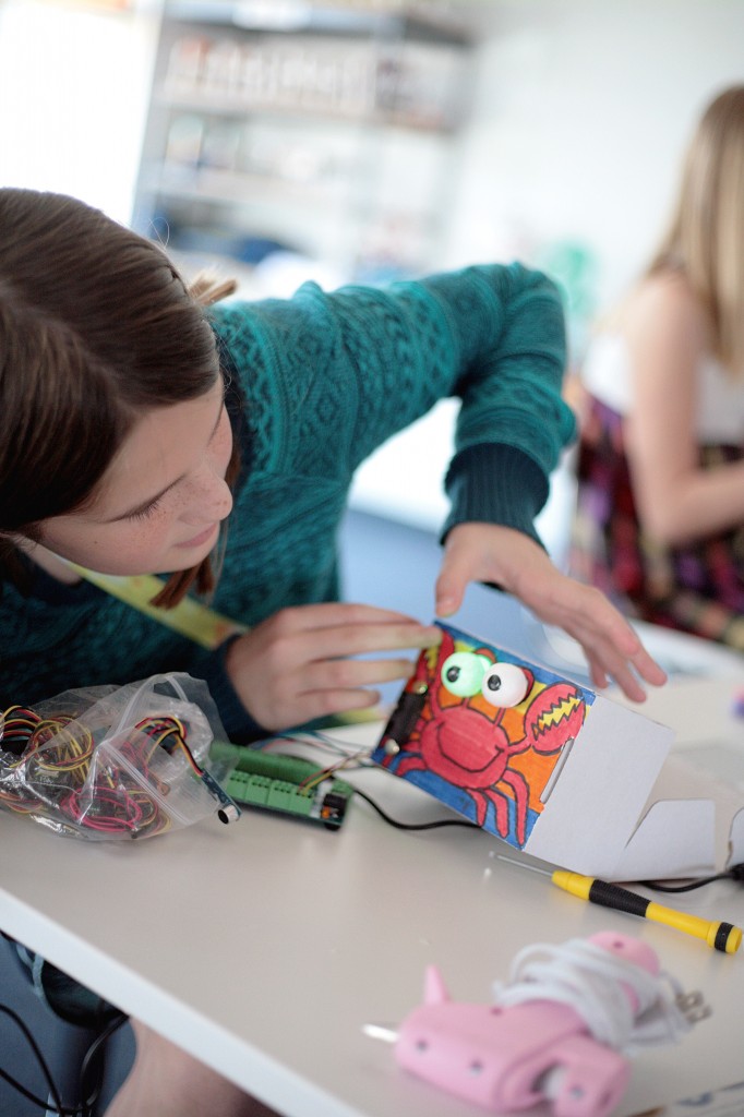 Kids test out their robotic projects at an ExplorOcean workshop on Tuesday. The colorful cardboard robots had parts that lit up and make sound.