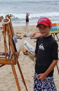 A young artist paints at the beach at a city summer camp last year.   — Photo courtesy the city of Newport Beach ©