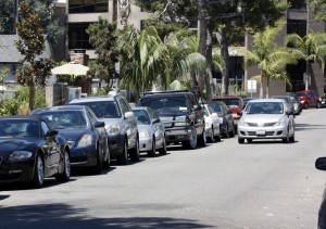 A car searches for a parking spot on Heliotrope in Corona del Mar