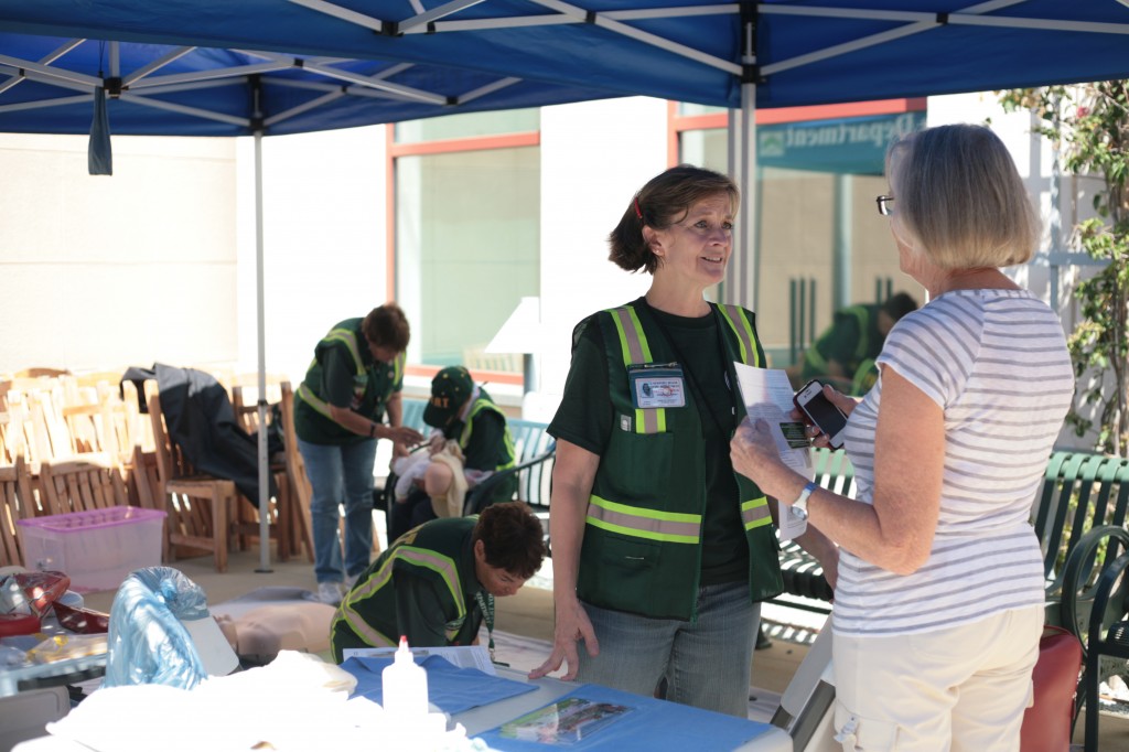 Community Emergency Response Team volunteers Shannon Inouye (front), and twin sisters Marilyn Broughton (middle) and Evalie DuMars (far back, left) teach visitors CPR and basic first aid during the Sixth Annual National Preparedness Expo Saturday. — Photo by Sara Hall ©