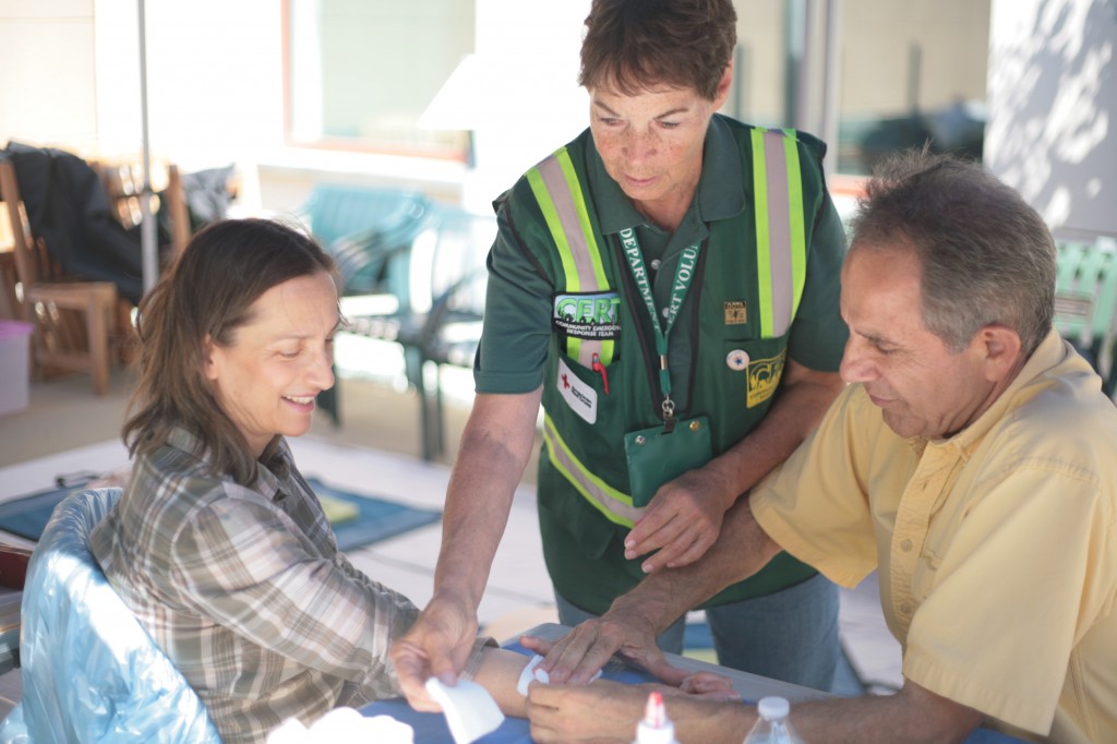 CERT volunteer Marilyn Broughton shows Newport Coast residents Faye and Ali Sadeghi some basic first aid skills during the expo Saturday. — Photo by Sara Hall ©