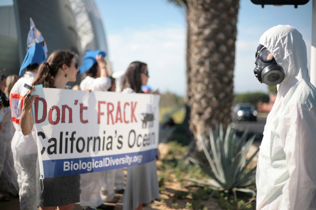 A demonstrator wears a gas mask and hazmat suit to protest fracking during the CCC meeting Wednesday. — Photo by Sara Hall ©