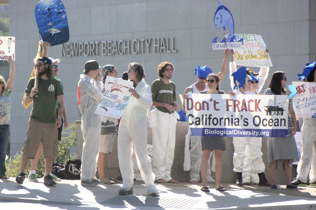 Protesters wave signs and shout chants against fracking Wednesday outside the Newport Beach City Hall, where the CA Coastal Commission was meeting this week. — Photo by Sara Hall ©