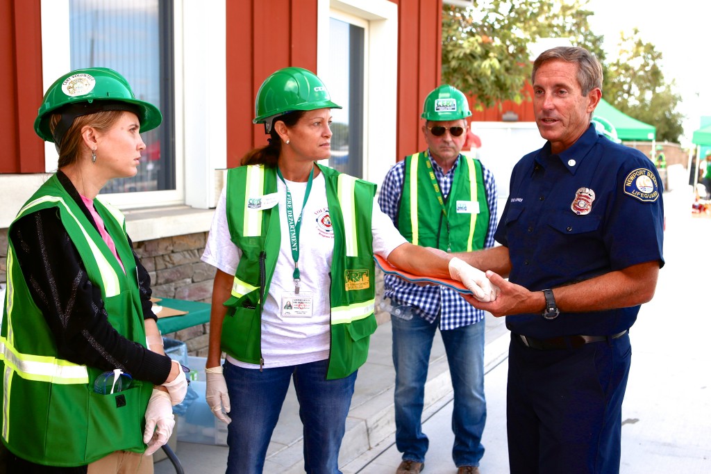 Newport Beach Fire Department Lifeguard Captain Mike Halphide shows Community Emergency Response Team volunteers how to set an injured arm during Saturday’s Drill the Skills event. — Photo by Jim Collins ©