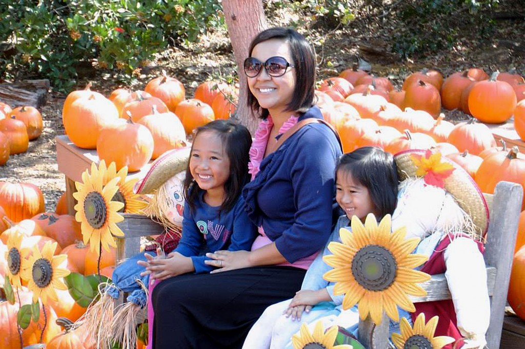 A family poses for a photo in the Environmental Nature Center’s pumpkin patch during the 2013 Fall Faire. — Photo by Lori Whalen ©