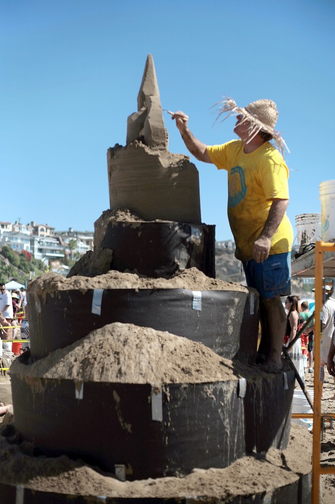 Chris Crosson, co-owner and president of Doggy Walk Bags, Inc., and Sandcastle Kits, works on a large castle structure for his company's team during the 53rd Annual Sandcastle Contest on Sunday, presented by the Commodore’s Club of the Newport Beach Chamber of Commerce. His team finished in first place for Most Unique Sandcastle. — Photo by Sara Hall ©