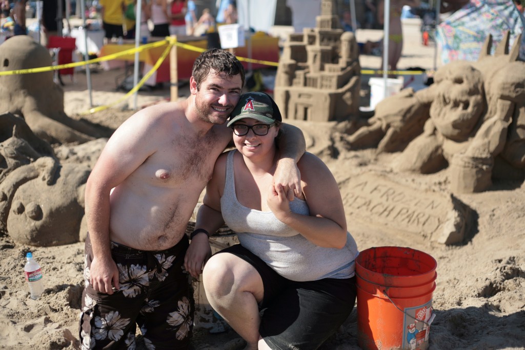 Eric Walker of Irvine and Stephanie Croft of Mission Viejo in front of their group's "Frozen" design. They were on Team ASCE OC, the American Society of Civil Engineers of Orange County, and ended up winning third place for Most Unique Sandcastle. — Photo by Sara Hall ©