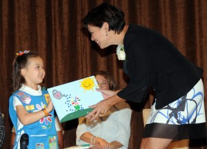 Girl Scout Daisy Kassidy Lee presents an art piece she created for honoree Betty Mower Potalivo, illustrating how Betty “makes people’s money grow.”