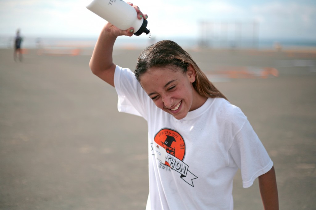 Gianna Milks, 12, a sixth grader at Newport El, cools down by dousing herself in water after running laps at the annual fundraising Jog-A-Thon. — Photo by Sara Hall