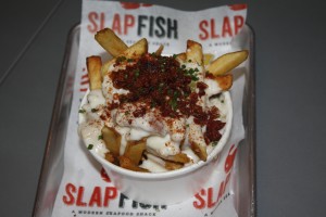 Fries topped with clam chowder and bacon bits at Slapfish