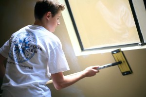 NLYM member Aidan Steinke, 14, prepares a room to be painted and refurbished at the safe haven location for women and children in the Human Options program.