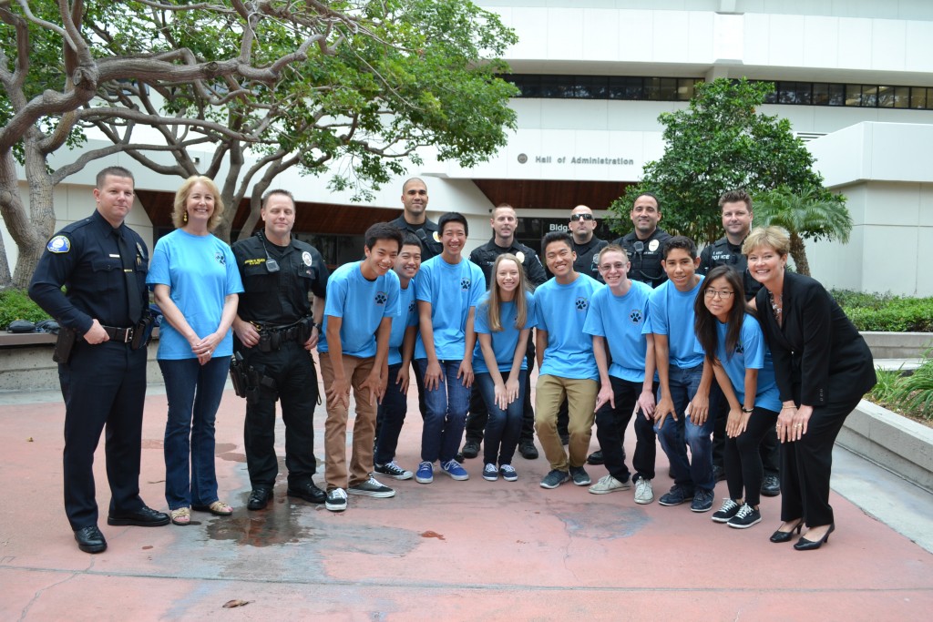 CdMHS Vest-A-Dog club members, staff advisor Tory Hughes (second from left), CdMHS Principal Kathy Scott (far right) and several local police officers pose for a photo Tuesday before the OC Board of Supervisors meeting. — Photo by Darla Conde