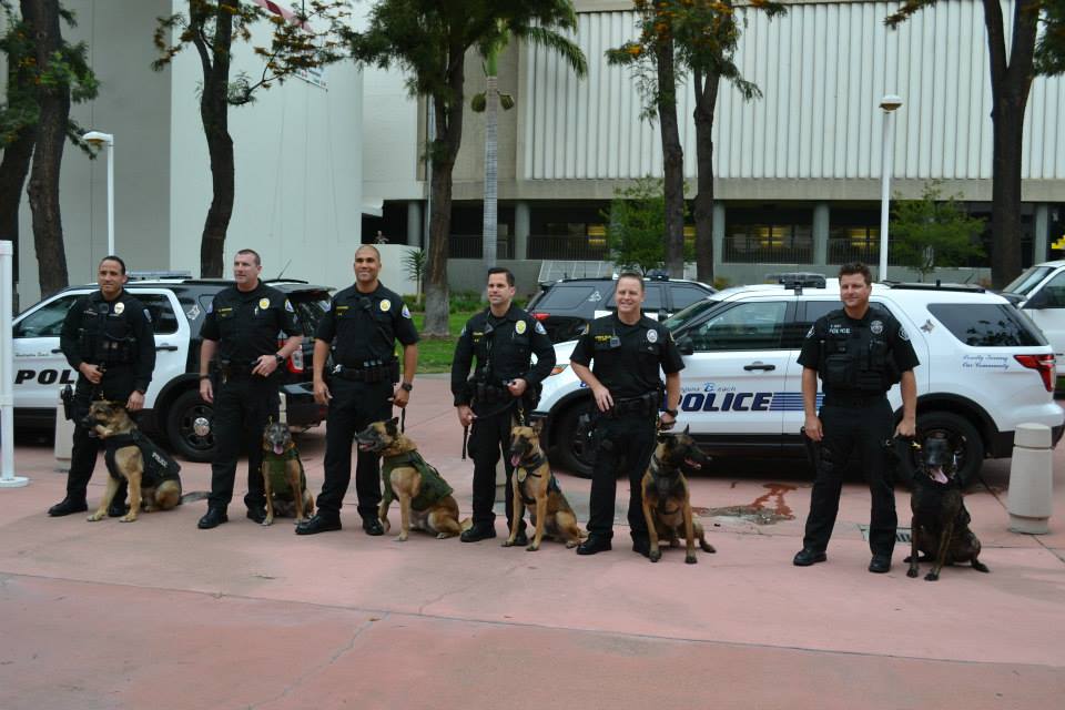 Local police officers and their K-9 partners pose for a photo Tuesday before the OC Board of Supervisors meeting.  — Photo by Darla Conde