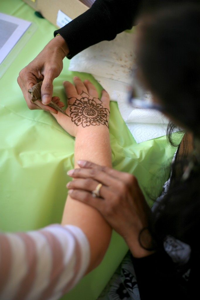 A young girl gets henna drawn on her hand at the World’s Playground during the Sage Hill Multicultural Fair.   — Photo by Sara Hall ©