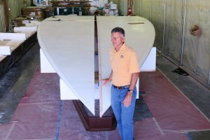 Newport Beach resident Bob Steel poses for a photo with the giant surfboard that he, the project manager, and his team hope to be breaking world records early next month. — Photo by Jim Collins ©