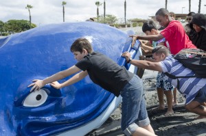 Children from the Speech and Language Development Center help push a giant floating whale into the Newport Dunes lagoon.  — Photo by Bill Gunn ©
