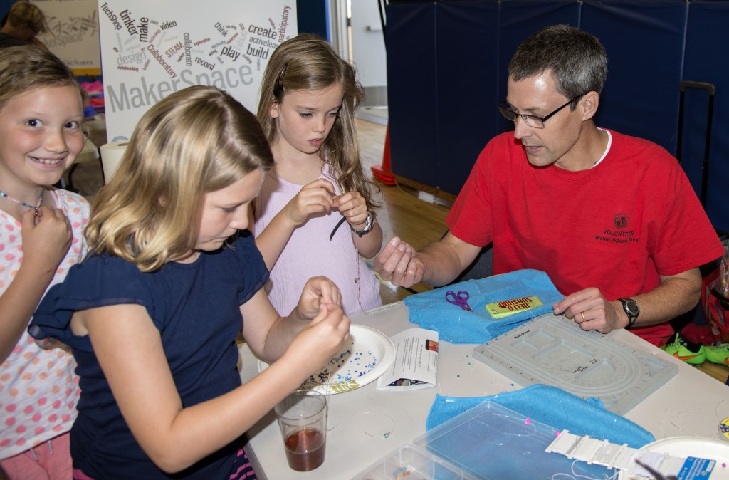 Harbor Day School Technology Director and Maker Faire organizer James Gapp helps students with a project at the event. — Photo by Charles Weinberg