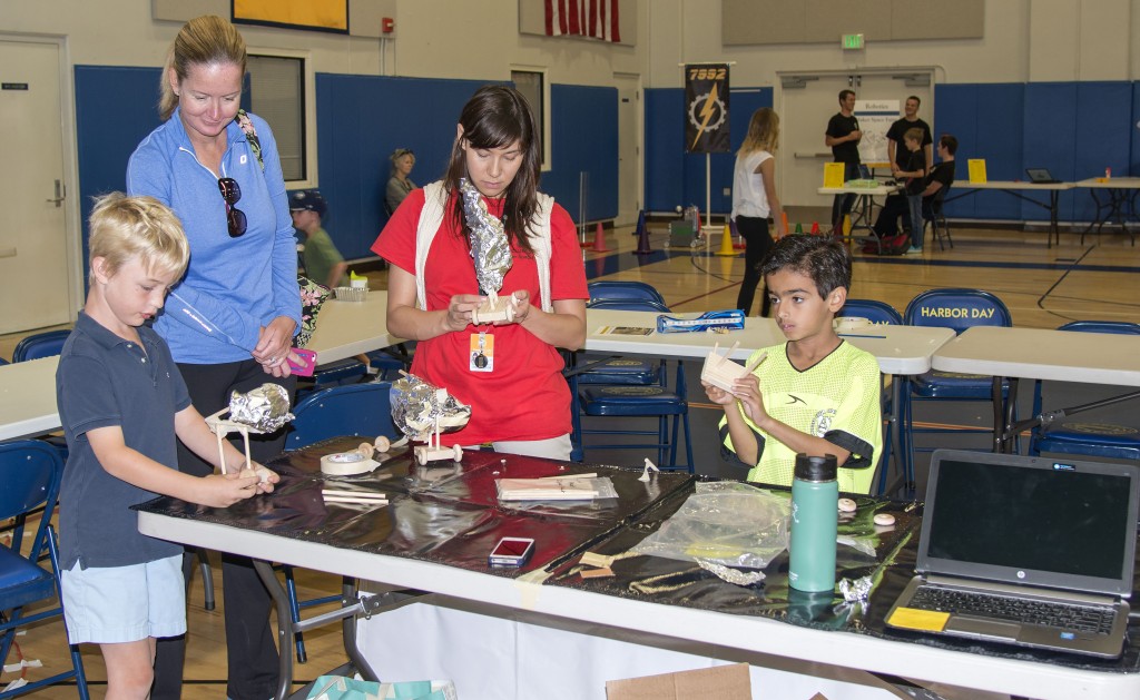 Jack Struve, 7, (far left) his mother (second from left) and Jake Pirnazar, 8, create “land yachts” at the Discovery Cube booth with the help of educational director Meredith Kiyomura (center) at the Harbor Day School Maker Faire on April 18. — Photo by Charles Weinberg