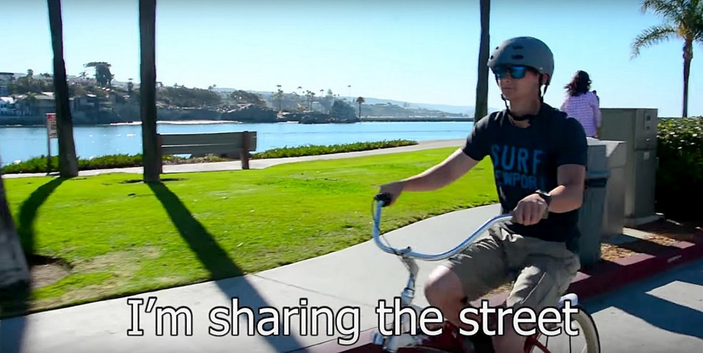 Newport Beach Police Department Cadet Connor Miller riding a bike in the NBPD’s new PSA video about sharing the road. — NBPD “Share the Road” YouTube video screenshot ©