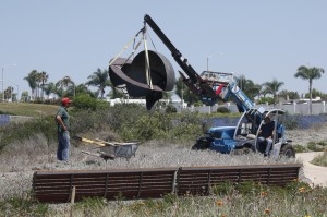 Workers lower “Act/Equator Z360” by Kenneth Capps into place in the park. Photo by Chris Trela