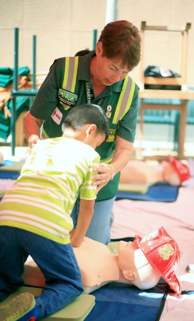 Newport Beach CERT volunteer Marilyn Broughton teaches Luther Nguyen, 7, of Garden Grove how to perform CPR during Saturday’s Preparedness Expo. — Photo by Sara Hall ©