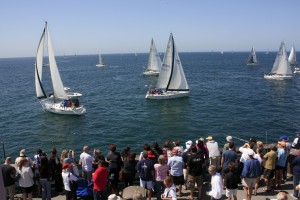 Locals and tourists crowd onto the Balboa Pier to watch the start of the Newport to Ensenada race