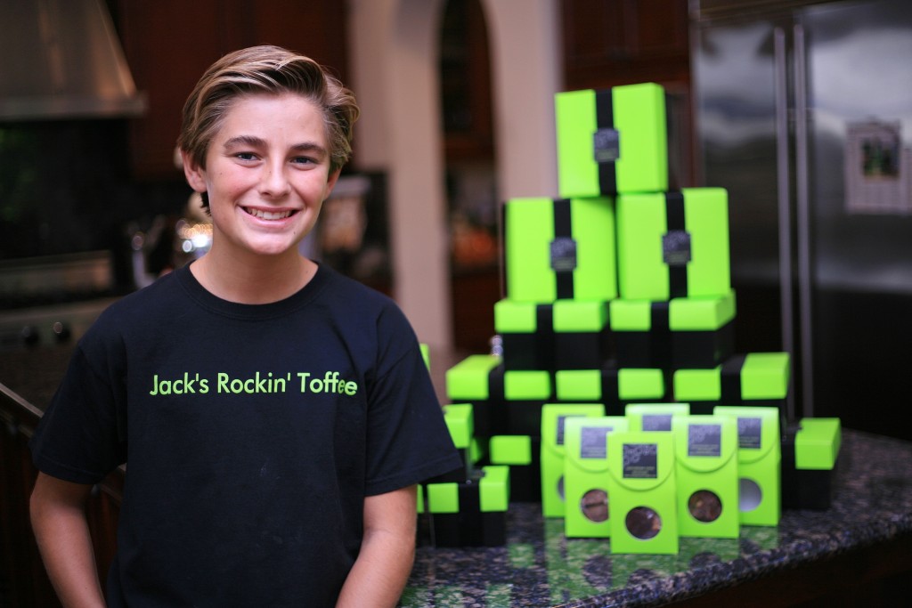 Founder and CEO of Jack’s Rockin’ Toffee, Jack McKenna, 14, of Newport Beach, poses for a photo with packages of his toffee. He earned an investment deal with an industry expert after appearing on the TV show “Hatched.” — Photo by Sara Hall ©