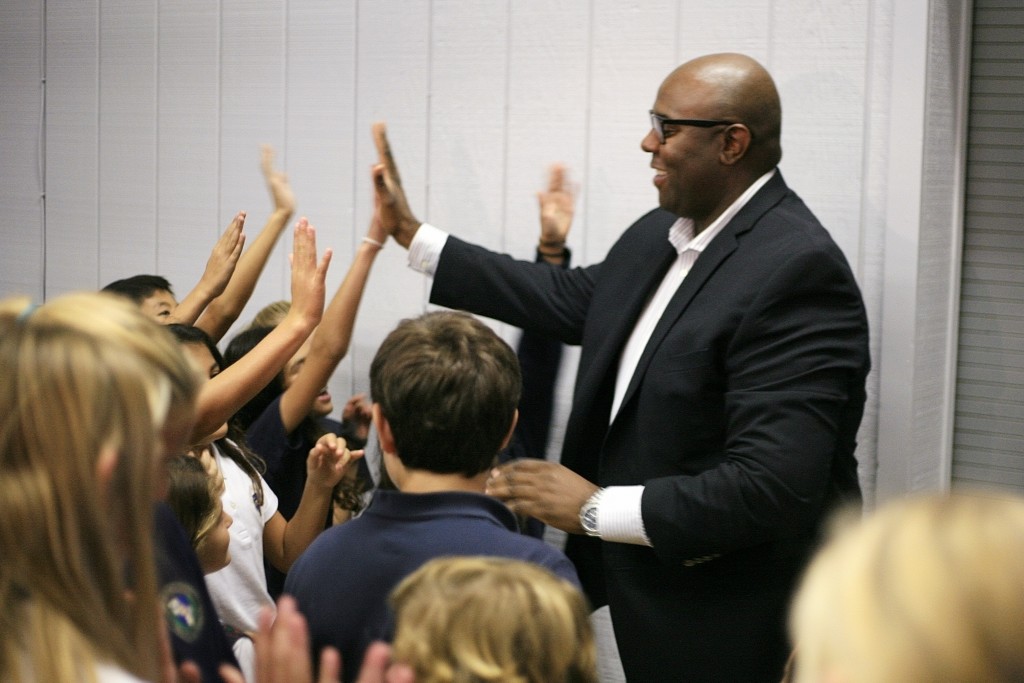 Retail expert Freddy Cameron gives high fives to Harbor Day students after the assembly. — Photo by Sara Hall ©