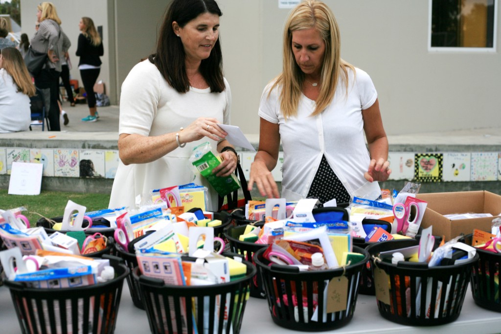 NCL moms (left) Chelle Wood, a philanthropy chair for the organization, and Stacy Peterson, the eighth grade level advisor, organize baskets full of donated items for Second Step. — Photo by Sara Hall ©