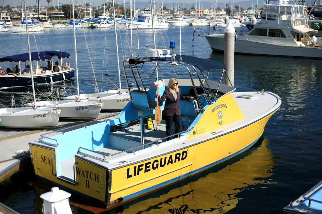 Former Newport Beach City Councilwoman Leslie Daigle poses for a photo on the NB lifeguard boat with a Marina Park commemorative oar. — Photo by Sara Hall ©