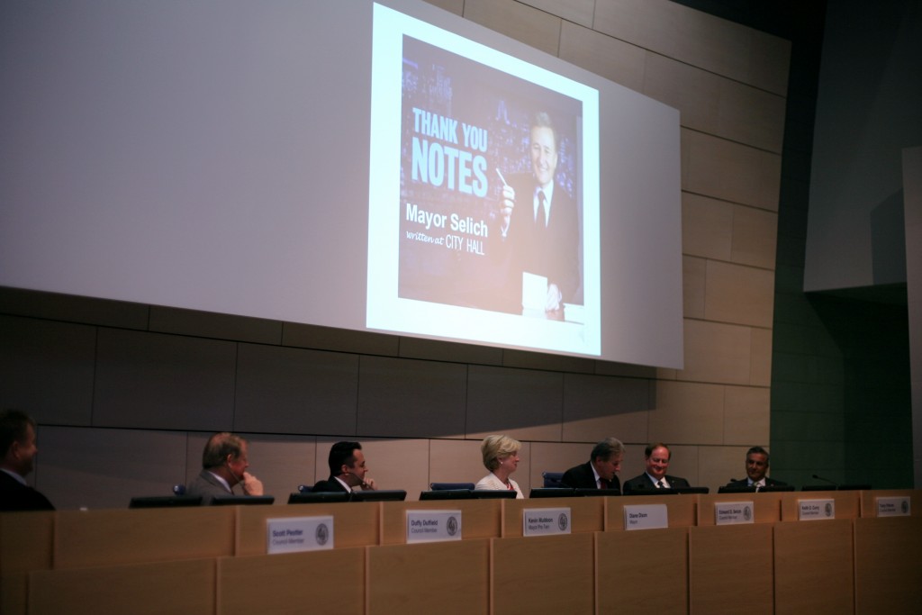 : Following the changing of seats on the dais, outgoing Mayor Ed Selich (third from right) reads his thank you notes during the meeting. — Photo by Sara Hall ©