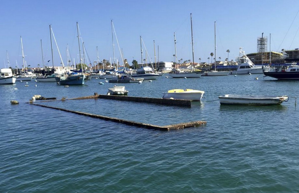 The top portion of the sunken Shellmaker, Inc., scow, Gemini, is still visible in Newport Harbor during low tide. It is scheduled to be removed within the next few weeks.  — Photo courtesy the city of Newport Beach ©