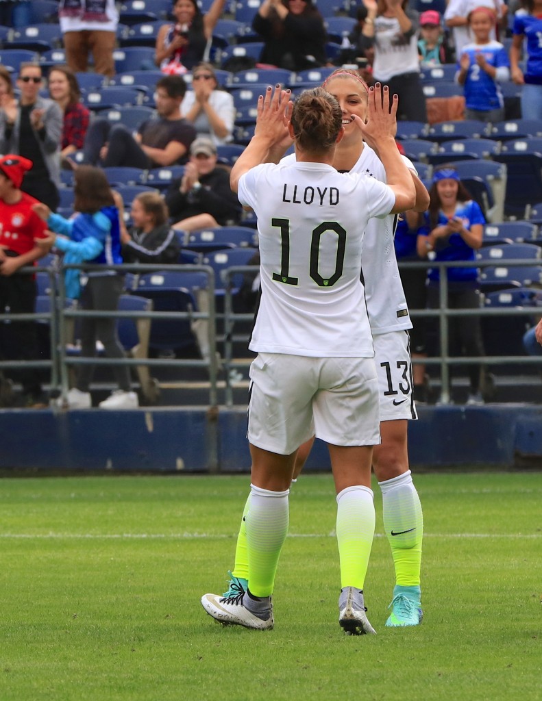 U.S. WNT players Carli Lloyd (#10) and Alex Morgan (#13) celebrate a victory. — Photo by Jim Collins ©