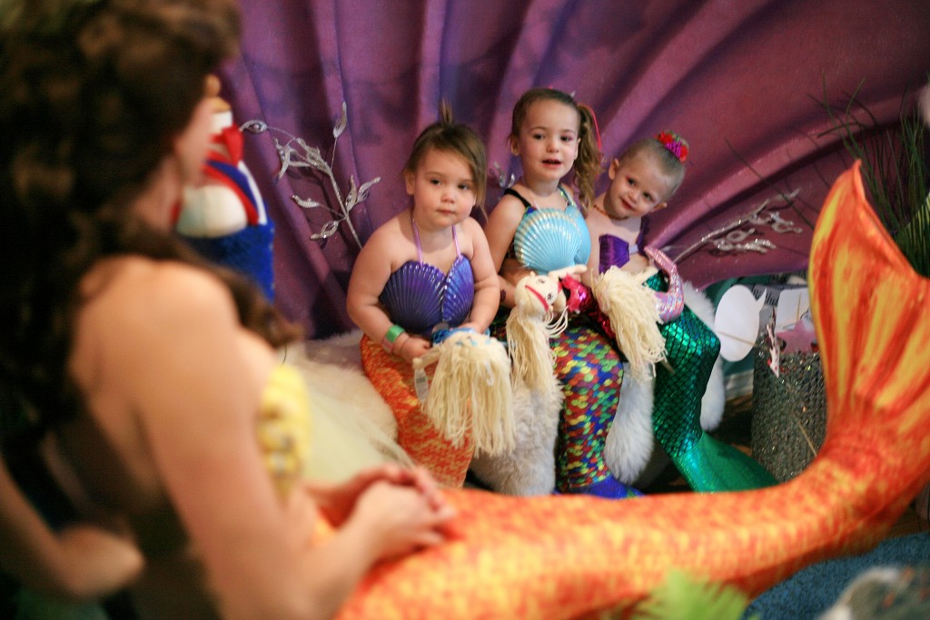 Mini mermaids (left to right) Madeline Unverferth, 2, Skylar Amirpur, 3, and Berlin Martin, 2, get excited as they see Princess Belle (transformed into a mermaid) come to visit. — Photo by Sara Hall ©