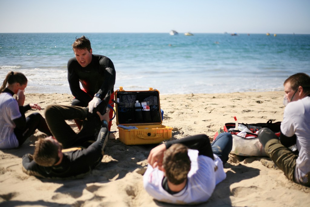 The first “victims” of the mock disaster are treated by Newport Beach lifeguards. — Photo by Sara Hall ©