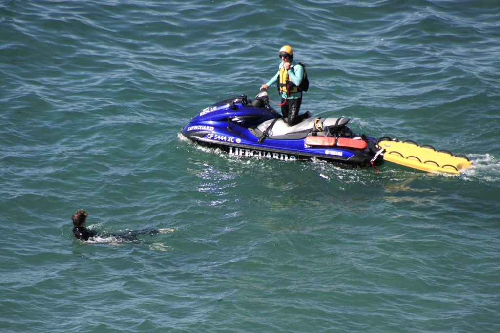 Lifeguards on personal watercraft rush to the aid of “victims” in the water during the drill. — Photo by Sara Hall ©