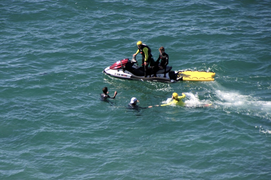 Lifeguards on personal watercraft rush to the aid of “victims” in the water during the drill. — Photo by Sara Hall ©