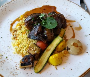 “I Am Africa” braised lamb shank with Moroccan couscous, apricot, pine nuts and roasted vegetables